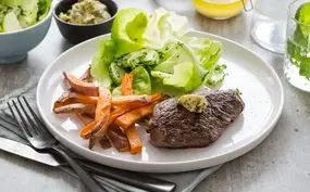 Steak frites met simpele beurre Café de Paris, zoete-aardappelfrietjes en tuinkruidensalade