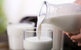 Rauwe melk dat wordt ingeschonken in een glas.