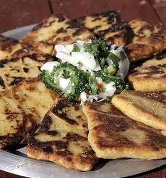 Paratha van yam gevuld met rode lentehoning-kip, geserveerd met sopropo-salade