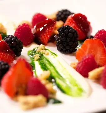 Rood fruit met een bite en basilicumstroop