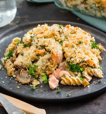 Romige boerenkoolpasta uit de oven met zalm, champignons en citroen