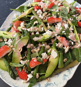 spinaziesalade met aardbeidressing op een bord
