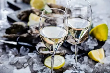 Twee wijnglazen met oesters op de achtergrond