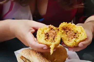 Miljuschka eet arancina op een streetfoodmarkt in Palermo.