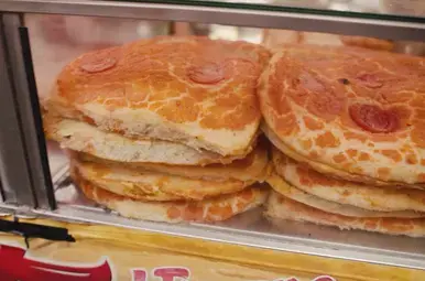 Miljuschka eet sfincione op een streetfoodmarkt in Palermo.