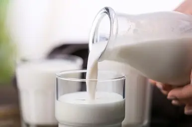 Rauwe melk dat wordt ingeschonken in een glas.