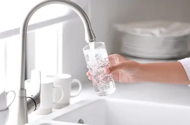 Een kraan die een glas vult met water.