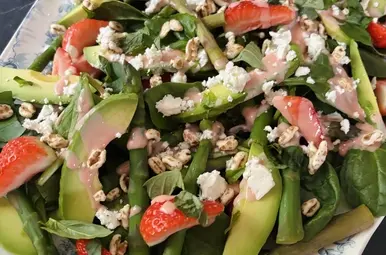 spinaziesalade met aardbeidressing op een bord