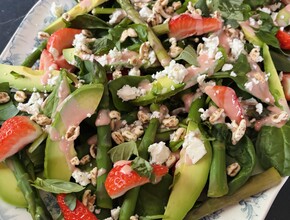 spinaziesalade met aardbeidressing op een bord