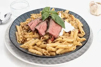 bord met pasta en rood vlees van de bbq