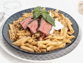 bord met pasta en rood vlees van de bbq