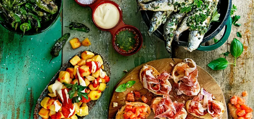 Patatas bravas, gegrilde sardines, toast met Spaanse ham en tomaat, gegrilde Padrón pepers