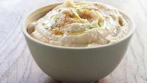 Crackers met hummus, avocado, tuinkers en Parmezaanse kaas