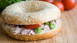 Bagel met zelfgemaakte tonijnsalade, cornichons en rode ui