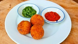 Arancini (risottokroketjes) met tomatensaus