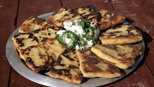 Paratha van yam gevuld met rode lentehoning-kip, geserveerd met sopropo-salade