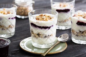 Feestelijke ontbijttrifle met laagjes jam, knapperige noten, voedzame muesli en yoghurt (of kwark).