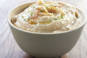 Crackers met hummus, avocado, tuinkers en Parmezaanse kaas