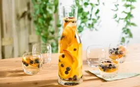 Witte sangria met perzik, sinaasappel en blauwe bessen