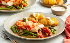 Hasselback patatas bravas met kabeljauwfilet in tomatensaus