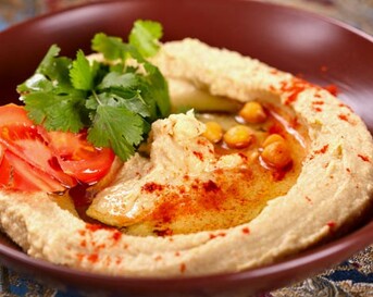 Hummus met tomaten en basilicum