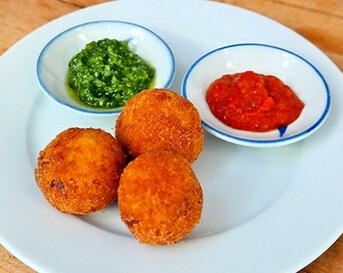 Arancini (risottokroketjes) met tomatensaus