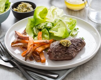 Steak frites met simpele beurre Café de Paris, zoete-aardappelfrietjes en tuinkruidensalade