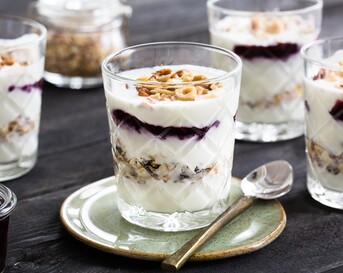 Feestelijke ontbijttrifle met laagjes jam, knapperige noten, voedzame muesli en yoghurt (of kwark).