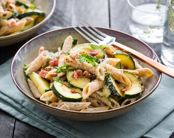 Magere penne carbonara met yoghurt, spekjes, courgette, Parmezaan en citroenrasp