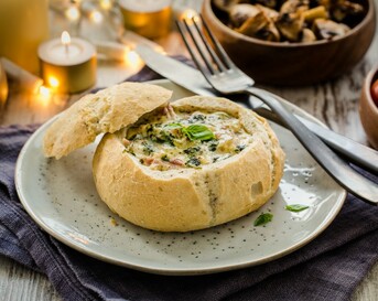 Roomkaasfondue geserveerd in knapperige broodjes met dips