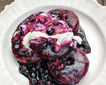Ontbijtdonuts met honing, blauwe bessen en yoghurt