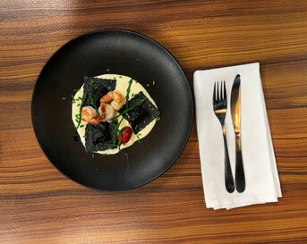 Ravioli met inktvisinkt, zeebaars, coquilles en gorgonzolasaus