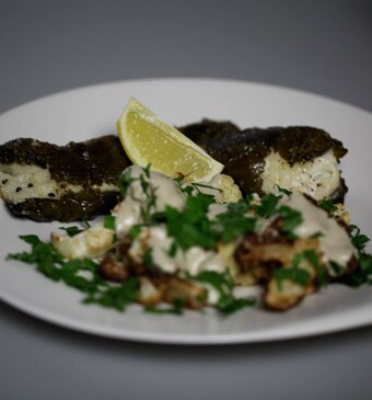 Vis in druivenbladeren met gefrituurde bloemkool en tahina