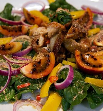 Maaltijdsalade met gekaramelliseerde kip, cassavemeel en wilde spinazie