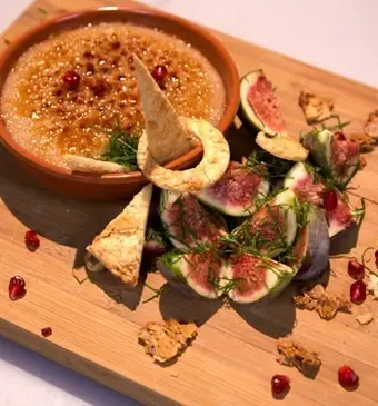 Gekaramelliseerde granaatappelmuhallebi met krokante amandelen en vijgen-muntsalade