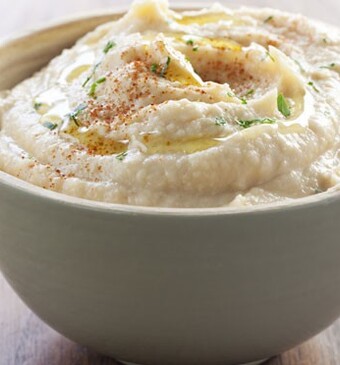 Crackers met hummus, avocado, tuinkers en Parmezaanse kaas