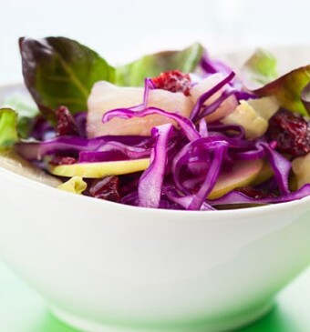 Rodekool-appelsalade met amandelen, rozijnen en granaatappeldressing