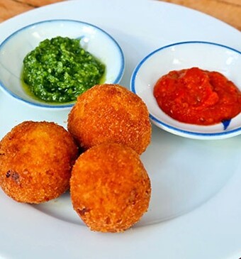 Arancini (risottokroketjes) met tomatensaus