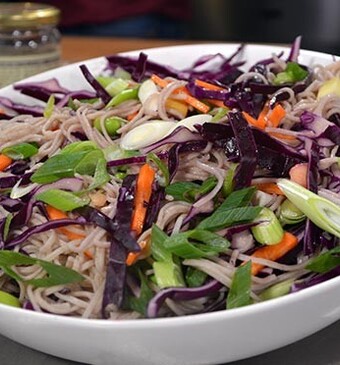 Sobanoedelsalade met sojabonen, rode kool, mango en kokoswaterdressing