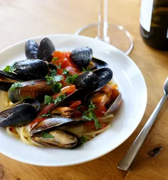 Pasta met mosselen met tomaat, knoflook, peterselie en citroen