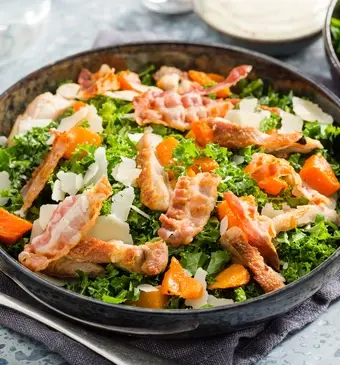 Winterse Caesarsalade met boerenkool, pompoen en gegrilde kip