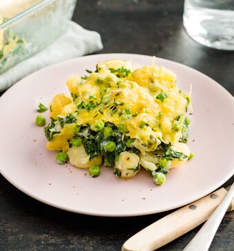 Romige gnocchi met doperwten, spinazie en graskaas uit de oven