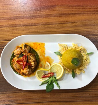 Ayam rica rica met nasi kuning, omelet en bananenblad