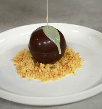 Chocoladebal met amandelbavarois en warme witte chocoladesaus