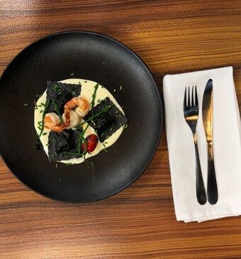 Ravioli met inktvisinkt, zeebaars, coquilles en gorgonzolasaus