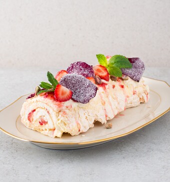 Pavlova-rol met aardbeien en rozenblaadjes
