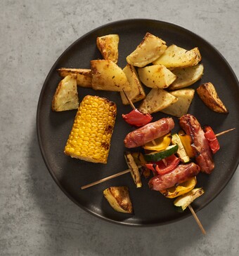 Maïskolf van de grill met worstspiesjes