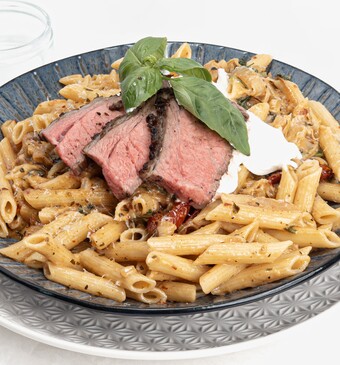 bord met pasta en rood vlees van de bbq