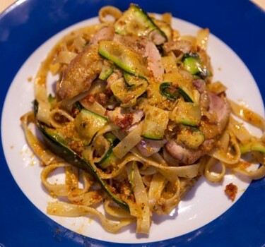 Tagliatelle met kippendijen, rode pesto en courgette