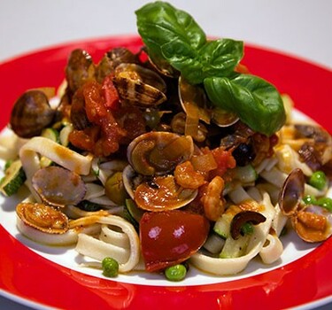 Tagliatella aan de zee (pasta met groene groente en rode zeevruchtensaus)